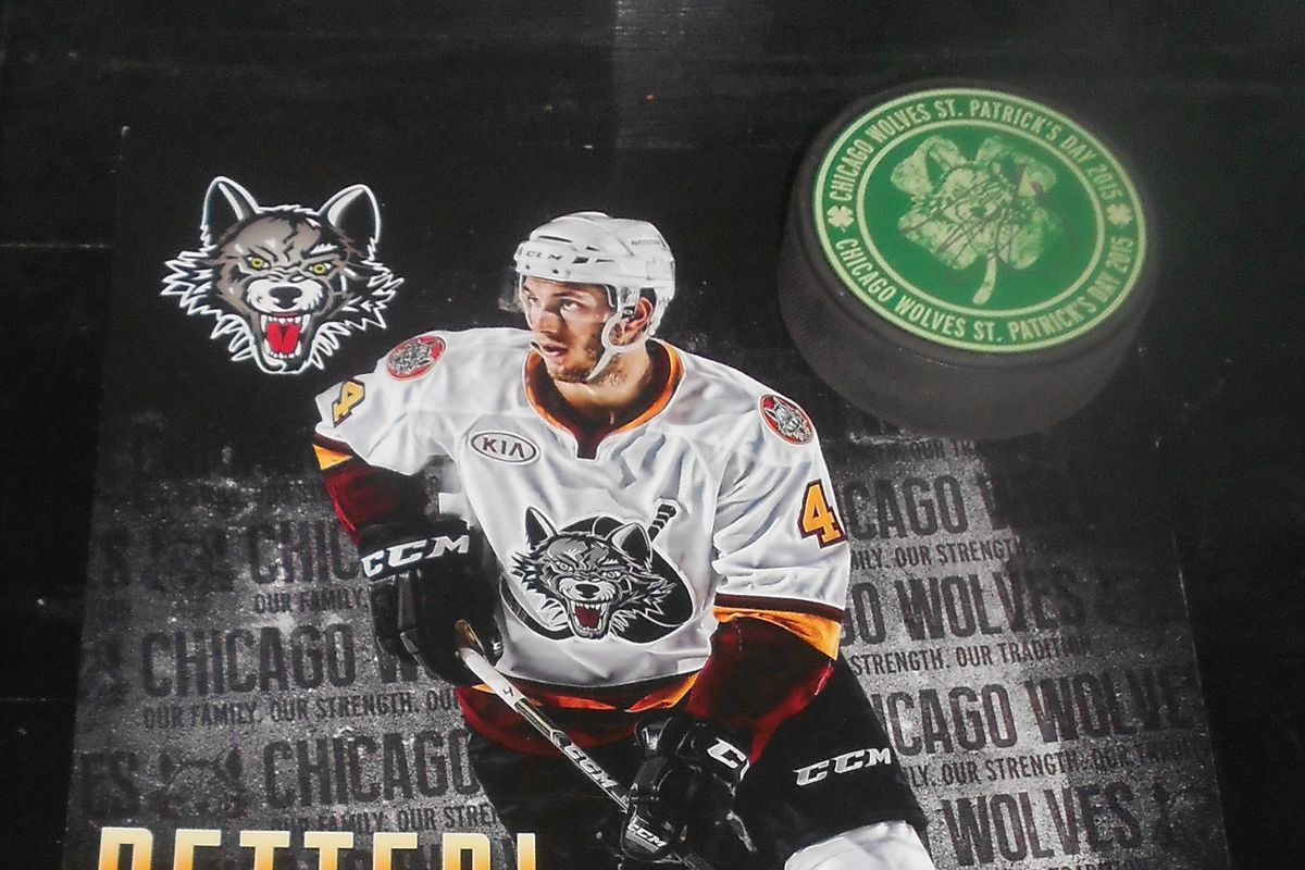 Wolves miniposter signed by Petteri Lindbohm with St. Patrick’s Day Wolves puck signed by Ty Rattie