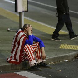 A man dressed in red-white-and-blue sits on the curb during a protest against President-elect Donald Trump on Nov. 9, 2016, in Seattle's Capitol Hill neighborhood. The election added stress to the daily lives of American voters. Here are four things voters should do to cope with the stress of the election, even after all of the votes have been counted.