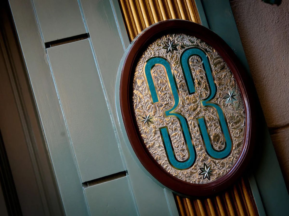 The low-key sign, written in teal, for a gaudy Disneyland club.