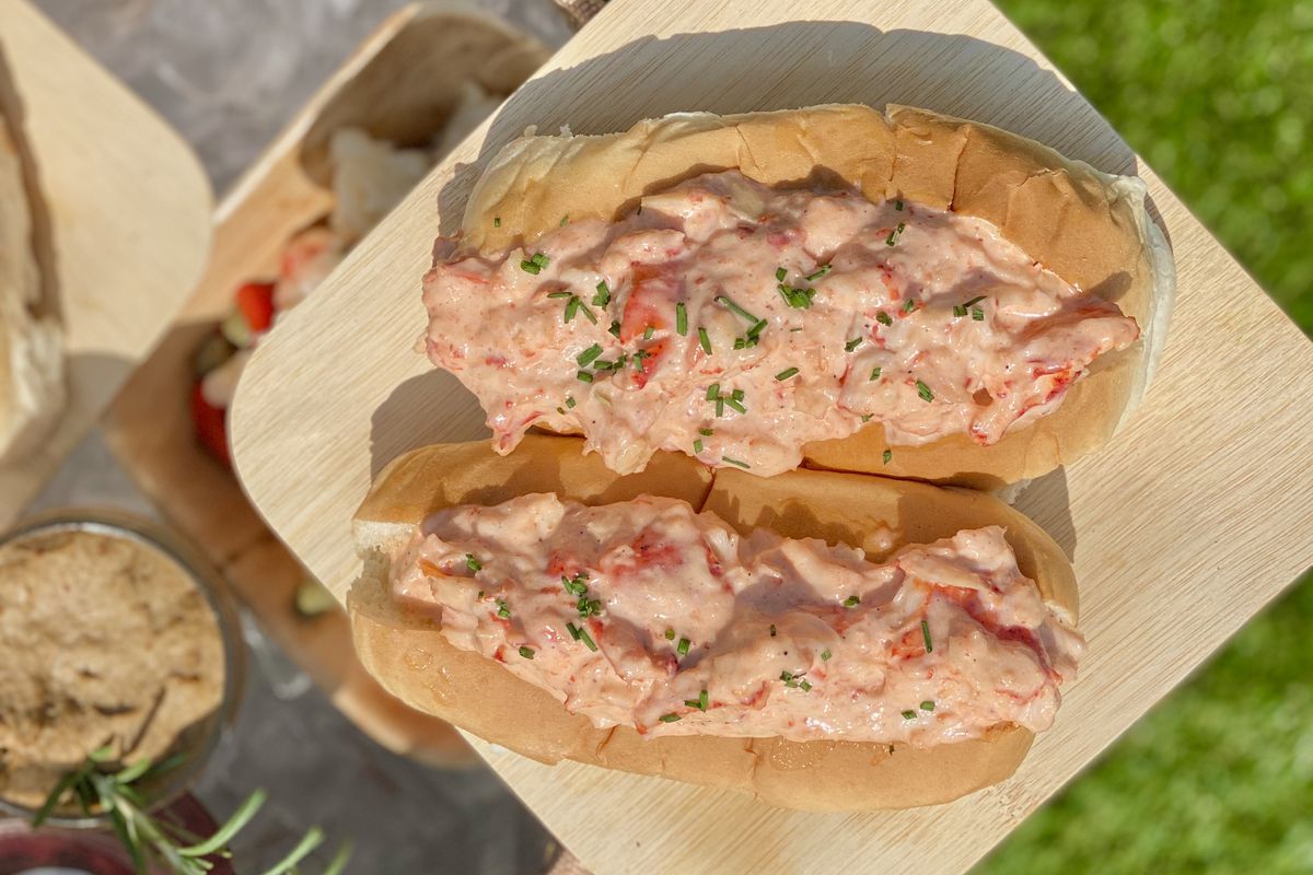 A paper plate shows off brown butter lobster rolls with celery root and chives