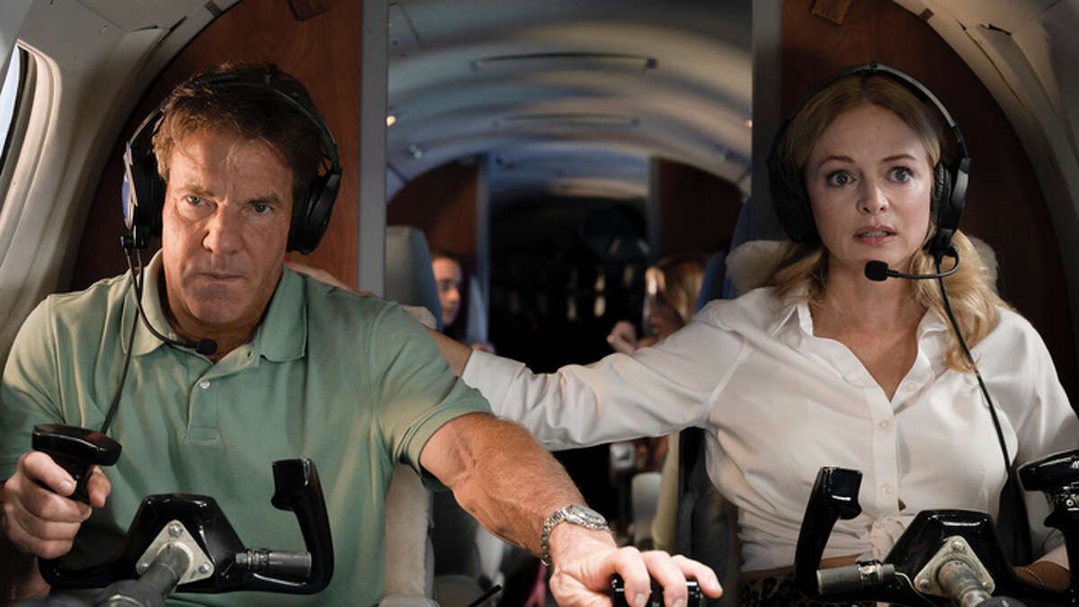 (L-R) Dennis Quaid and Heather Graham seated behind the controls of a plane in On a Wing and a Prayer.