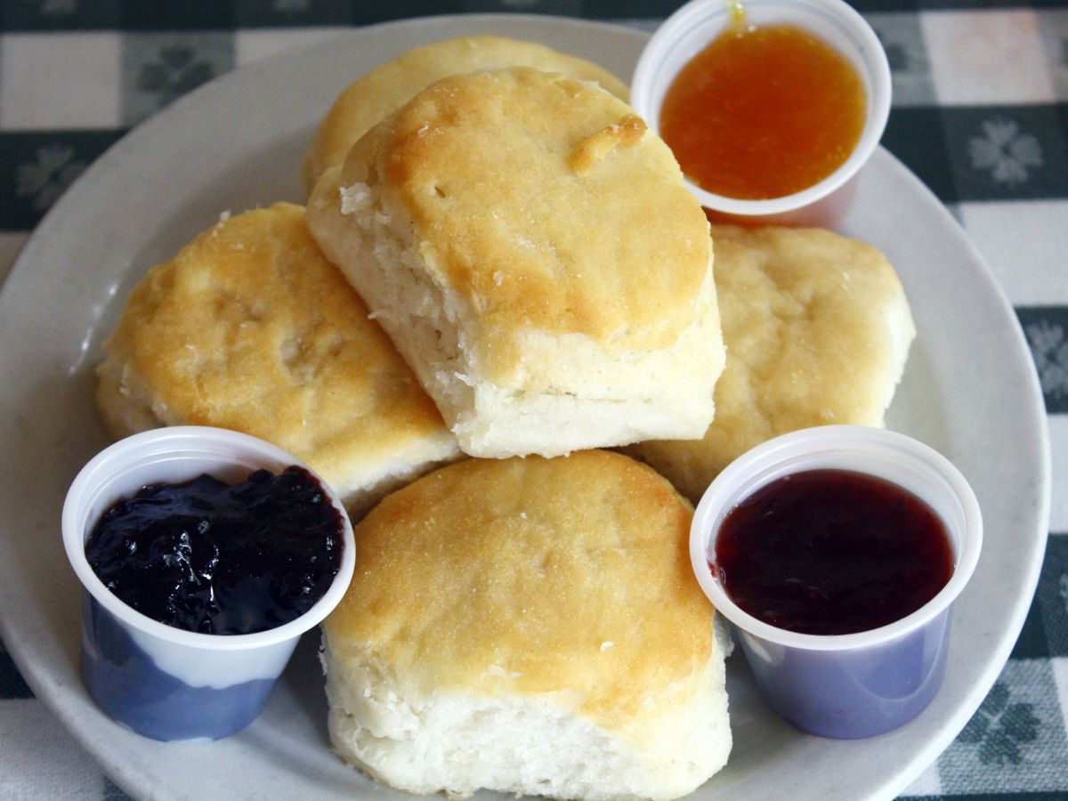 A plate of biscuits with three jams.