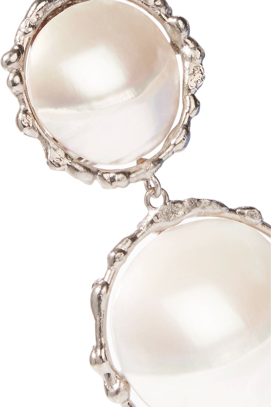 A close up of large pearl earrings