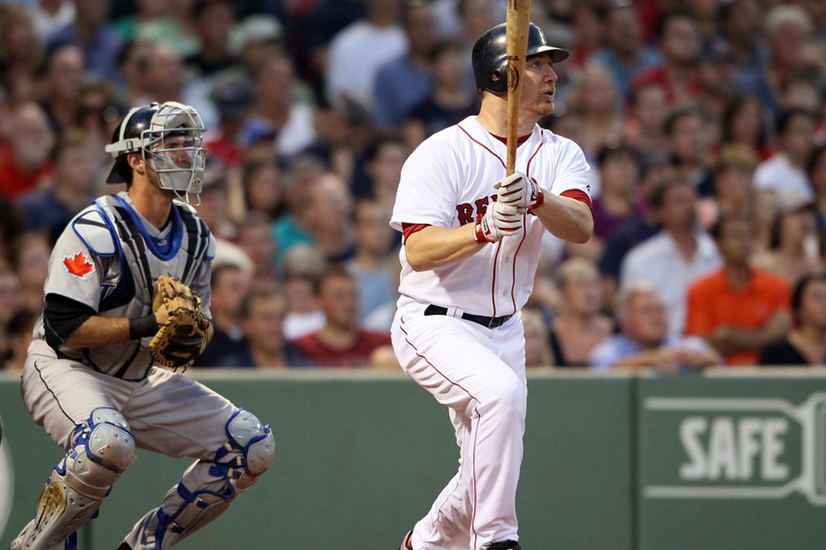 BOSTON, MA - JULY 06:  J.D. Drew #7 of the Boston Red Sox hits a single as J.P. Arencibia #9 of the Toronto Blue Jays defends in the fourth inning on July 6, 2011 at Fenway Park in Boston, Massachusetts.  (Photo by Elsa/Getty Images)