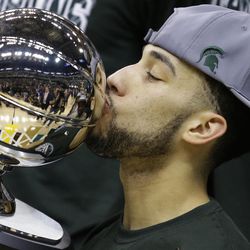 Michigan State's Denzel Valentine (45) kisses the championship trophy after an NCAA college basketball game against Purdue in the finals at the Big Ten Conference tournament, Sunday, March 13, 2016, in Indianapolis. Michigan State won 66-62. 