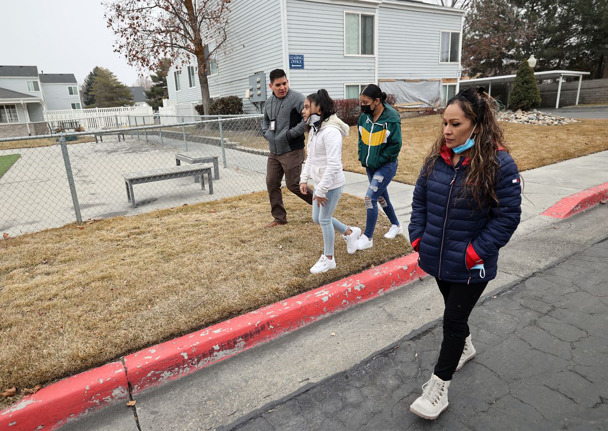Danial Hernandez, a victim advocate, left, walks with sisters Jennifer Ramirez 10, and Citlalli Ramirez 14, and the girls’ mother, Juana Segura, outside of their old apartment in South Salt Lake on Friday, Feb. 5, 2021. The family was displaced after a Hyundai sedan crashed into it on Jan. 22, injuring Jennifer.