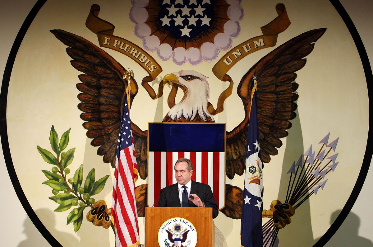 Assistant Secretary Of State Kurt Campbell speaks at a wooden podium in front of a massive mural of the US presidential seal.