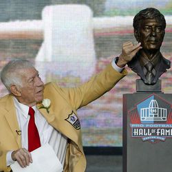 FILE- In this Aug. 6, 2011, file photo, Ed Sabol touches a bust of himself after it was unveiled during the induction ceremony at the Pro Football Hall of Fame in Canton, Ohio. Sabol, the NFL Films founder who revolutionized sports broadcasting and transformed pro football from an up-and-coming sport to must-watch theater died Monday, Feb. 9, 2015, the league said. He was 98. 