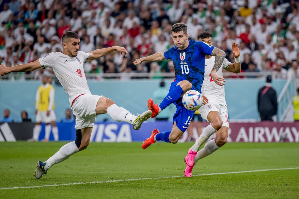Christian Pulisic (C) of USA scores his team’s first goal past Majid Hosseini (L) and Amir Abedzadeh of Iran during the FIFA World Cup Qatar 2022 Group B match between IR Iran and USA at Al Thumama Stadium on November 29, 2022 in Doha, Qatar.