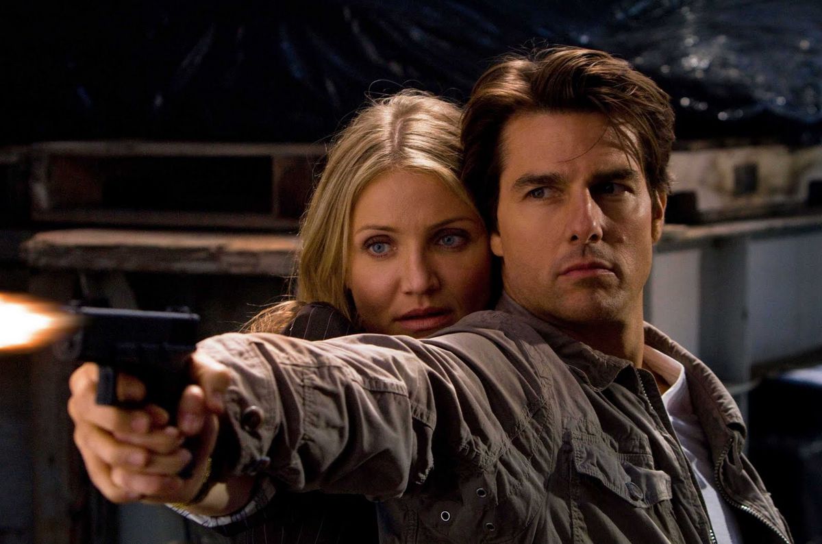 Tom Cruise and Cameron Diaz hold a gun together in Knight &amp; Day