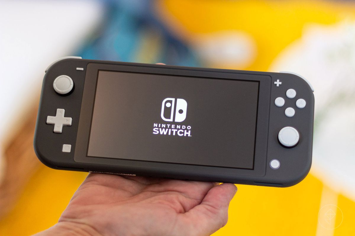a gray Nintendo Switch Lite sitting in a hand