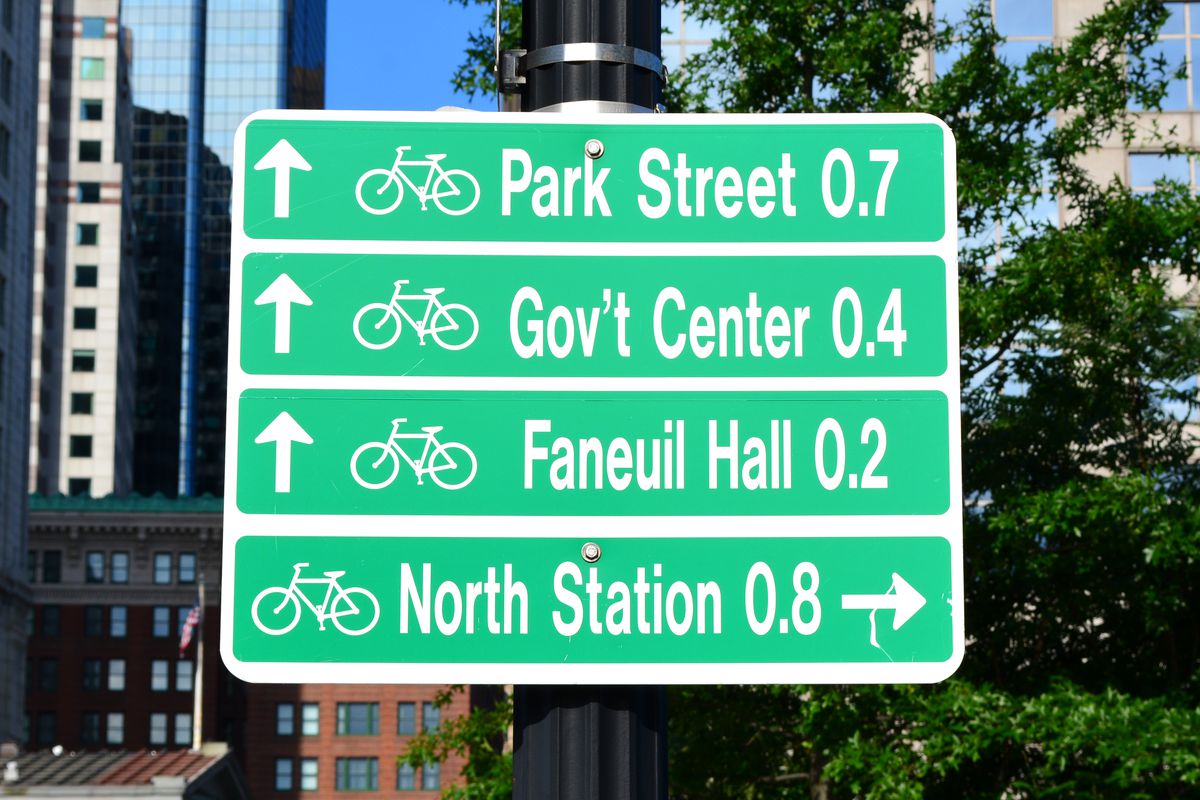 A street sign showing the distances for bikers to certain Boston destinations.