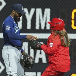 APRIL 25: Teoscar Hernandez #35 of the Seattle Mariners hands the Philadelphia Phillies ballgirl a hotdog that was on the field in the bottom of the ninth inning at Citizens Bank Park on April 25, 2023 in Philadelphia, Pennsylvania. The Seattle Mariners defeated the Philadelphia Phillies 5-3.