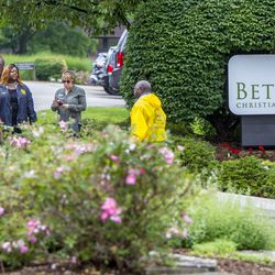 A group of people stand near Bethany Christian Services in Grand Rapids on Wednesday, June 27, 2018, after a rally protesting the separation of immigrant children from their families at the southern border. Some of the children are currently being housed at BCS. (Cory Morse/The Grand Rapids Press via AP)