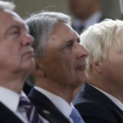 From left, Britain's chief Brexit negotiator David Davis, Chancellor of the Exchequer Philip Hammond and Foreign Secretary Boris Johnson attend a speech by Prime Minister Theresa May, in Florence, Italy, Friday Sept. 22, 2017. May will try Friday to revive foundering Brexit talks — and unify her fractious government — by proposing a two-year transition after Britain's departure from the European Union in 2019 during which the U.K. would continue to pay into the bloc's coffers.