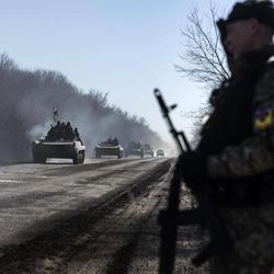 Ukrainian troops ride on armoured vehicles near Artemivsk, eastern Ukraine, Tuesday, Feb. 24, 2015. Ukrainian officials said they haven’t yet started pulling heavy weapons back from a frontline in eastern Ukraine because of continued rebel violations of a cease-fire deal. 