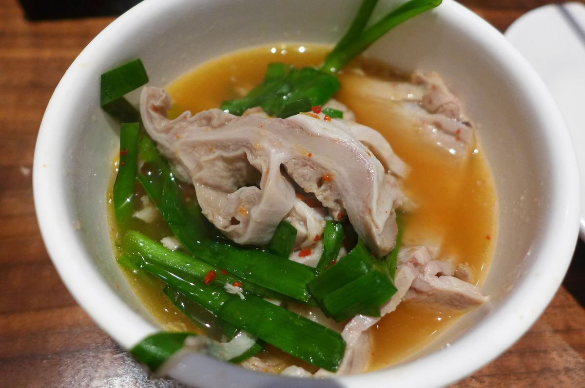 A small bowl with pig parts in it, including bowel.