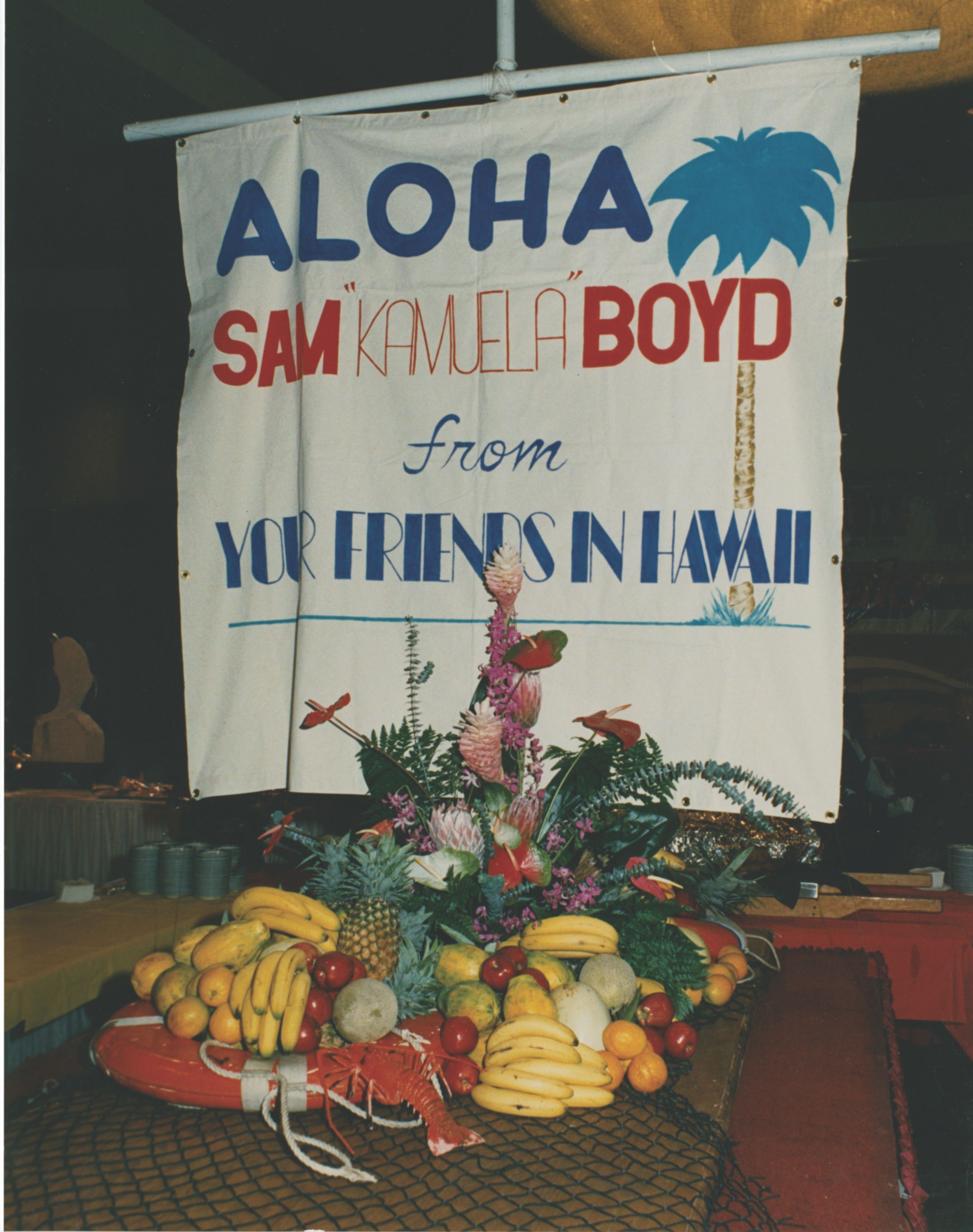 A sign with fruit arranged beneath it. 