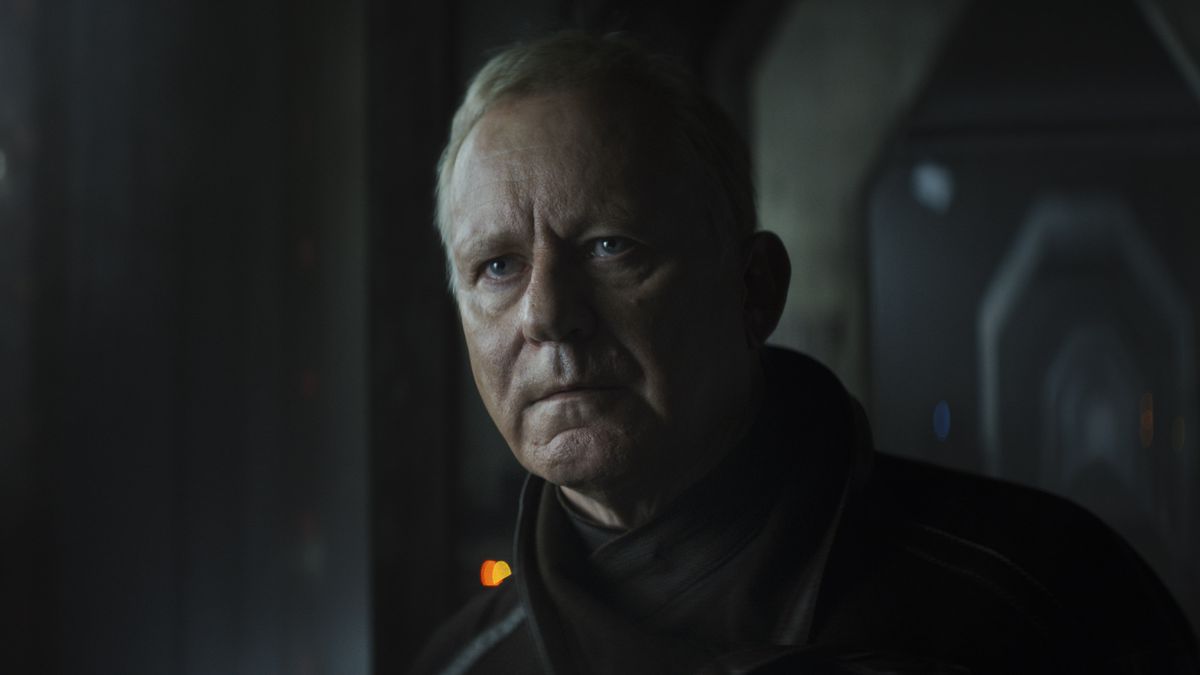 Luthen Rael (Stellan Skarsgard) with a serious look and a black coat in Andor.