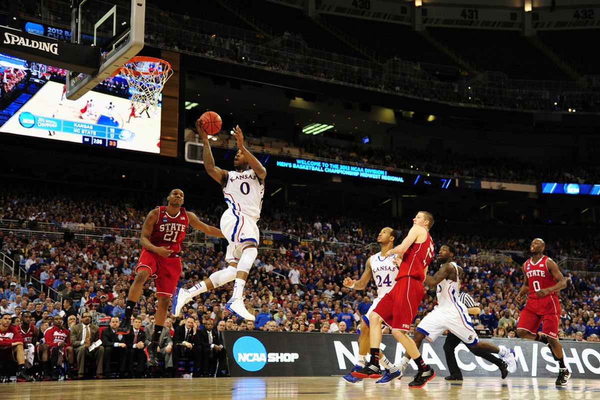 Kansas Jayhawks forward Thomas Robinson shoots as North Carolina State Wolfpack guard/forward C.J. Williams trails during the first half of the semifinals in the midwest region of the 2012 NCAA men's basketball tournament.
