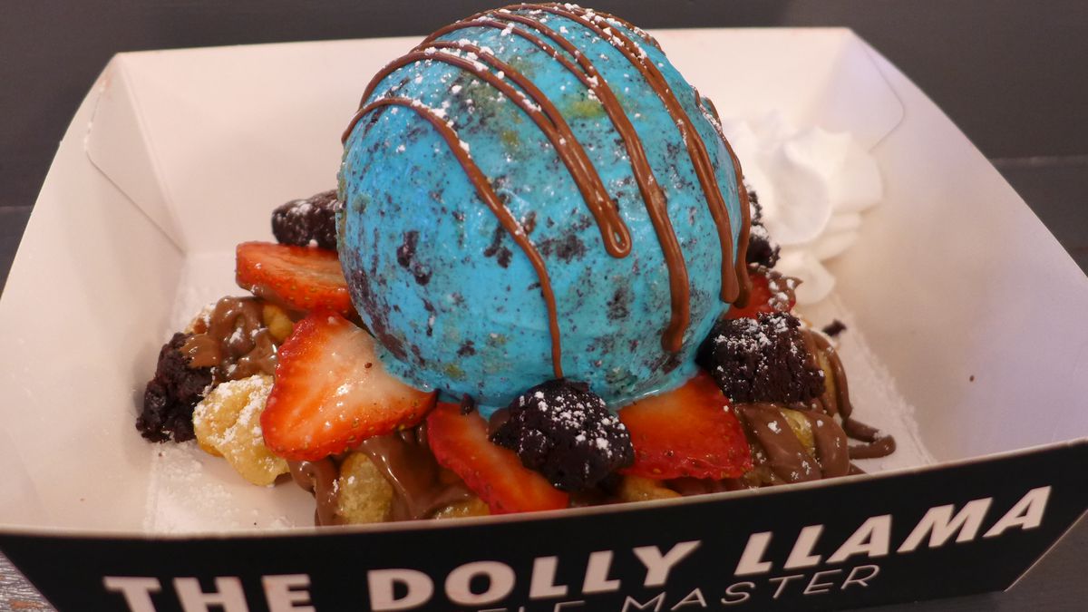 A scoop of very blue ice cream with syrups and other toppings.