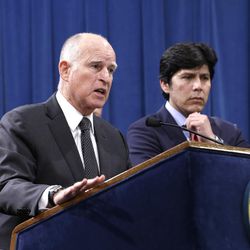Accompanied by labor leaders and Senate President Pro Tem Kevin de Leon, D-Los Angeles, second from right, California Gov. Jerry Brown discusses proposed legislation to increase the state's minimum wage to $15 per hour by 2022, during a news conference in Sacramento, Calif. Monday March 28, 2016. If approved by the Legislature, California would be the first state to raise the minimum wage to $15. 