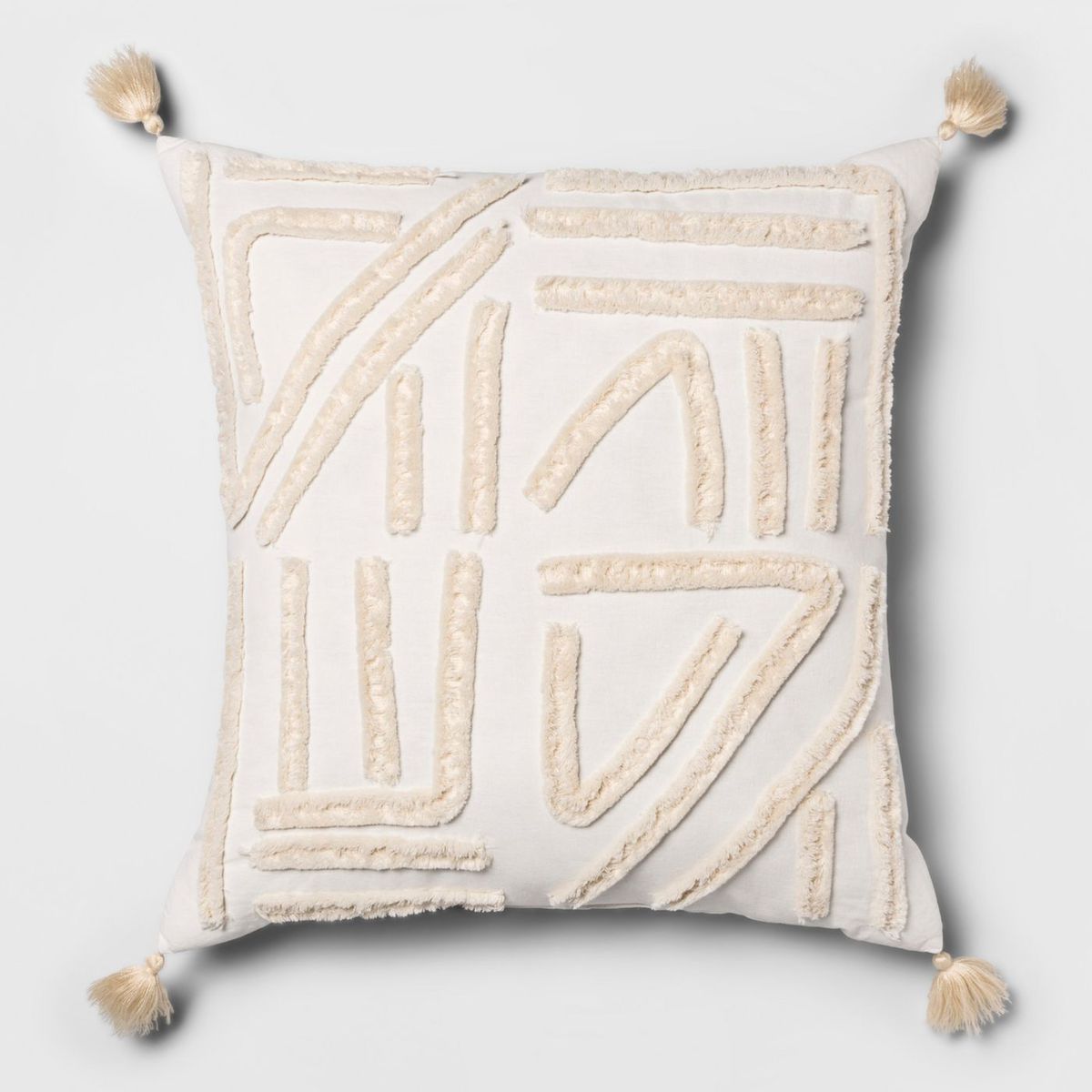 Beige pillow with tassels. 