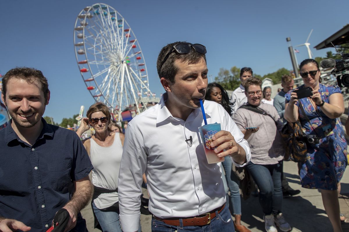 Mayor Pete walks with a supporters while drinking a slushie