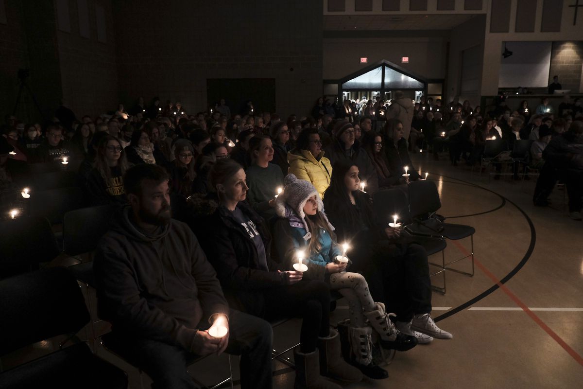 Scores of students, teachers, parents, and community members hold a candlelight vigil following a school shooting.