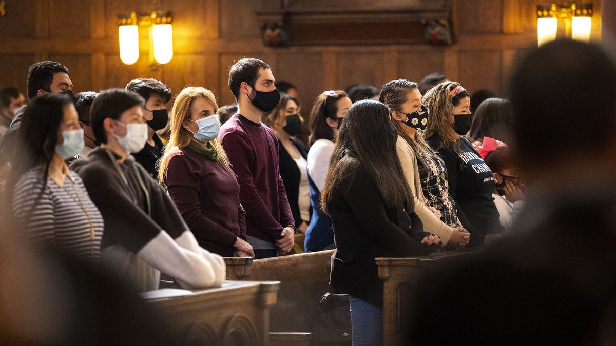 Worshipers wearing masks stand and sing at a Palm Sunday service behind the Cathedral of the Madeleine in Salt Lake City on Sunday, March 28, 2021.