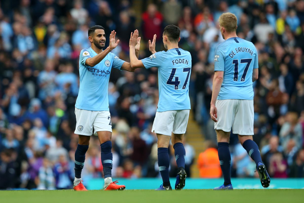 Riyad Mahrez of Manchester City celebrates after scoring his team’s fourth goal with Phil Foden during the Premier League match between Manchester City and Burnley FC at Etihad Stadium on October 20, 2018 in Manchester, United Kingdom.