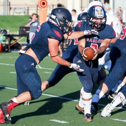 Ethan Morley (2) gives the ball to Owen Huff (6) up the middle. American Leadership Academy defeats Layton Christian Academy 17-10 Friday, August 25, 2017.