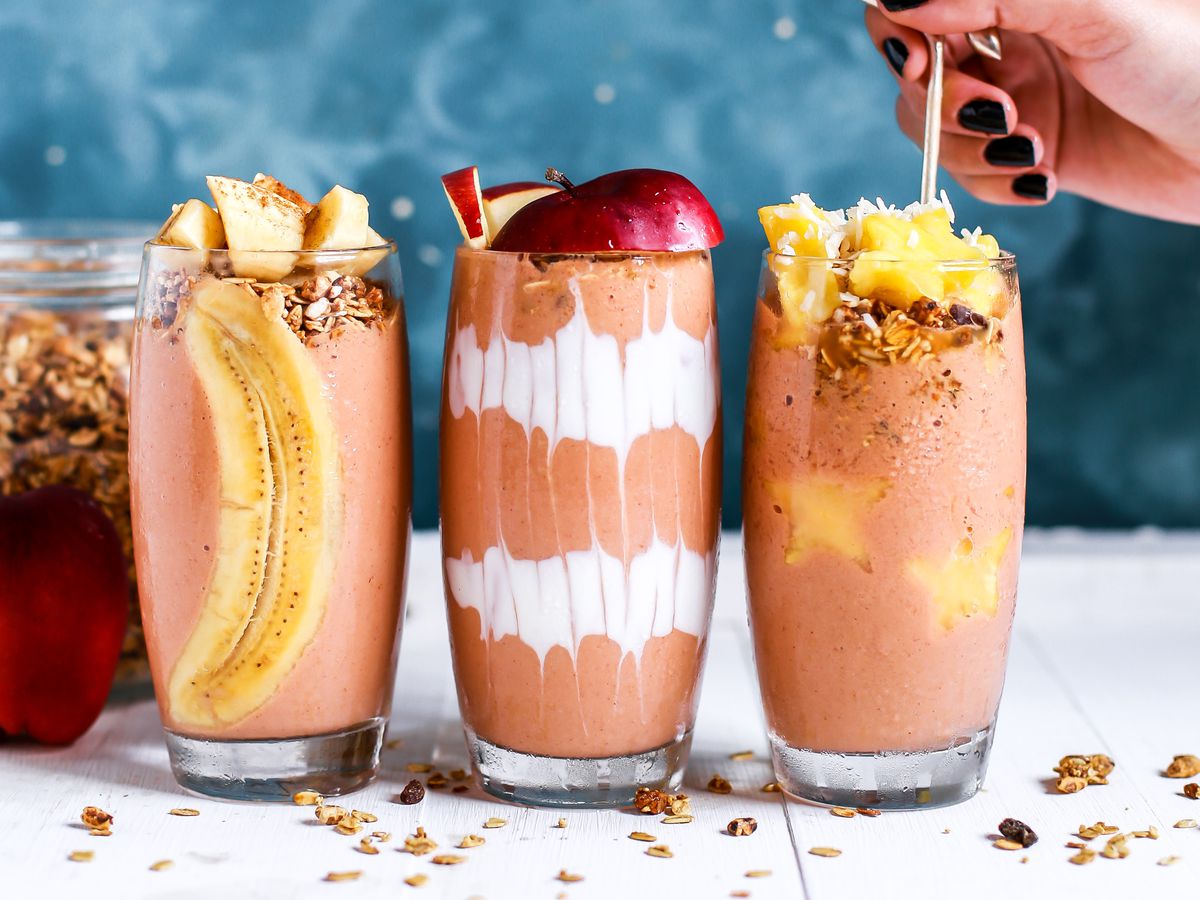 three smoothies with a hand.