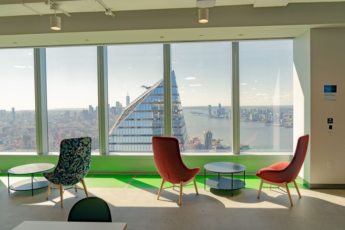 Chairs sit in the sunlight at a Meta office space in the Farley Building in New York, on September 29, 2021. The city view is beyond.
