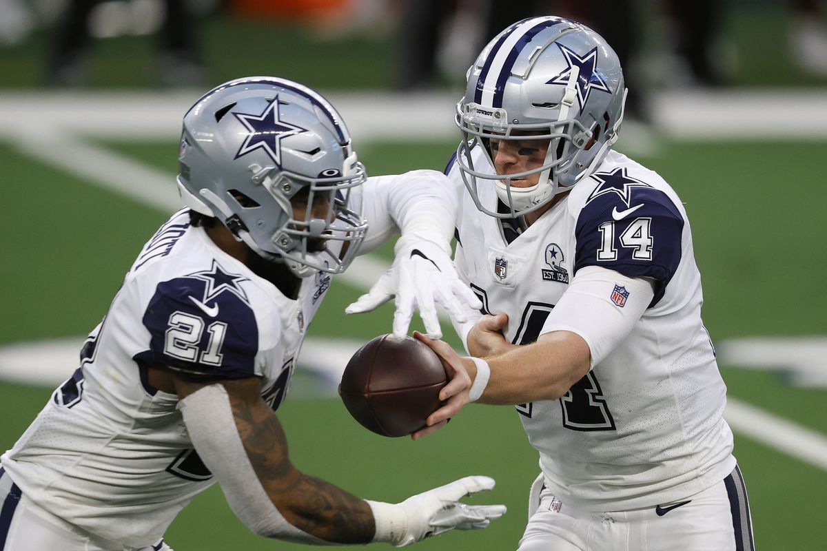 Andy Dalton #14 of the Dallas Cowboys hands of to Ezekiel Elliott #21 during the second quarter of a game against the Washington Football Team at AT&amp;T Stadium on November 26, 2020 in Arlington, Texas.