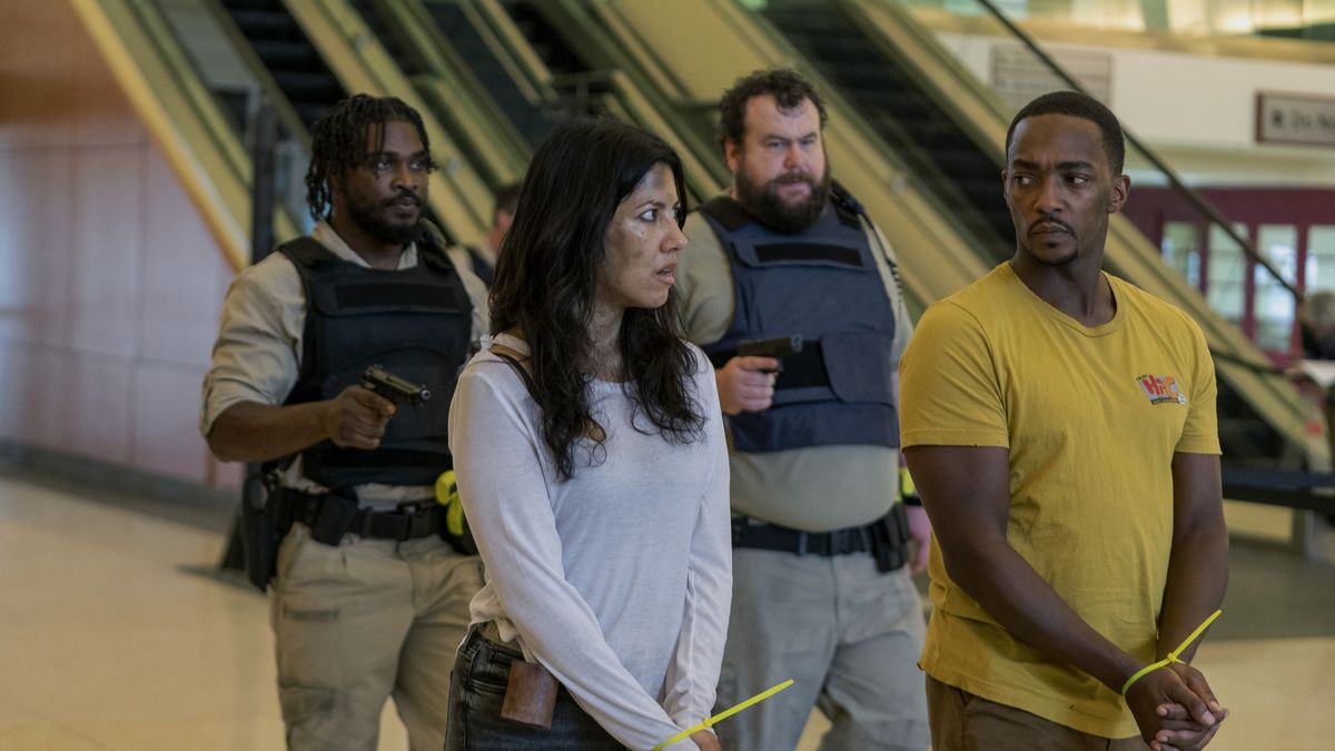 Stephanie Beatriz as Quiet and Anthony Mackie as John Doe in Twisted Metal, being led through a mall in hand ties