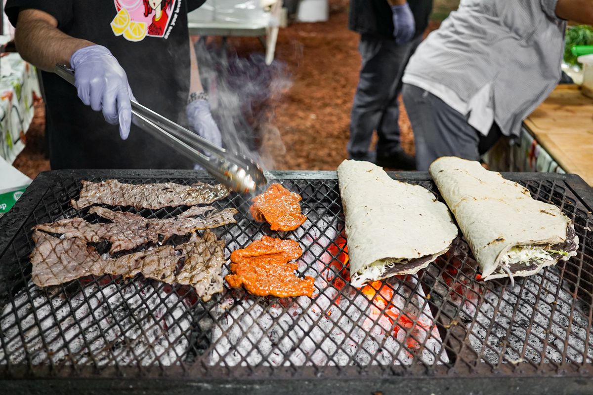 A charcoal grilled topped with thinly sliced steak and tortillas for tlayudas.