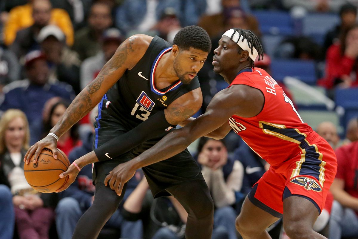 Los Angeles Clippers forward Paul George controls the ball against New Orleans Pelicans guard Jrue Holiday in the second half at the Smoothie King Center.