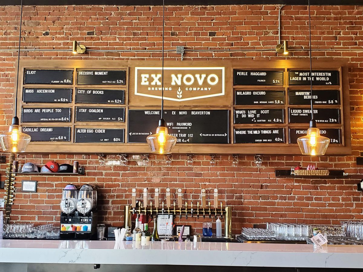 A bar and taplist are shown, lit with both indoor and natural lighting