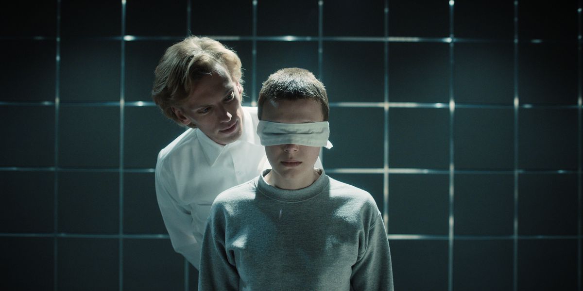 henry in orderly uniform looks behind eleven blindfolded people in strange things