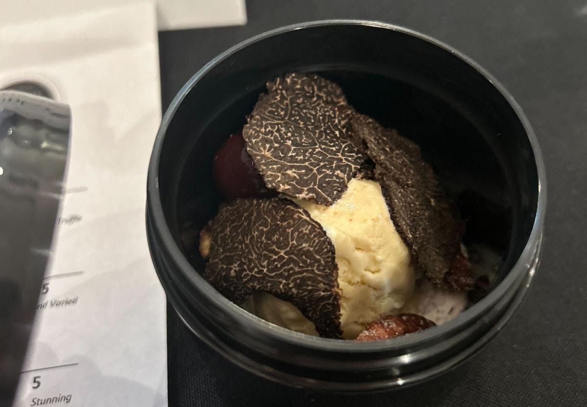 A black bowl holds ice cream and truffles.