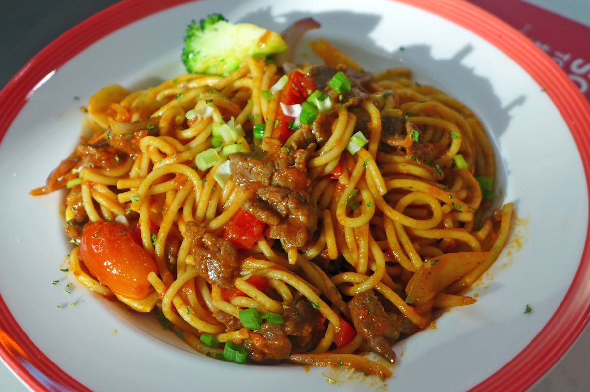 Spaghetti with red sauce and swatches of beef. 