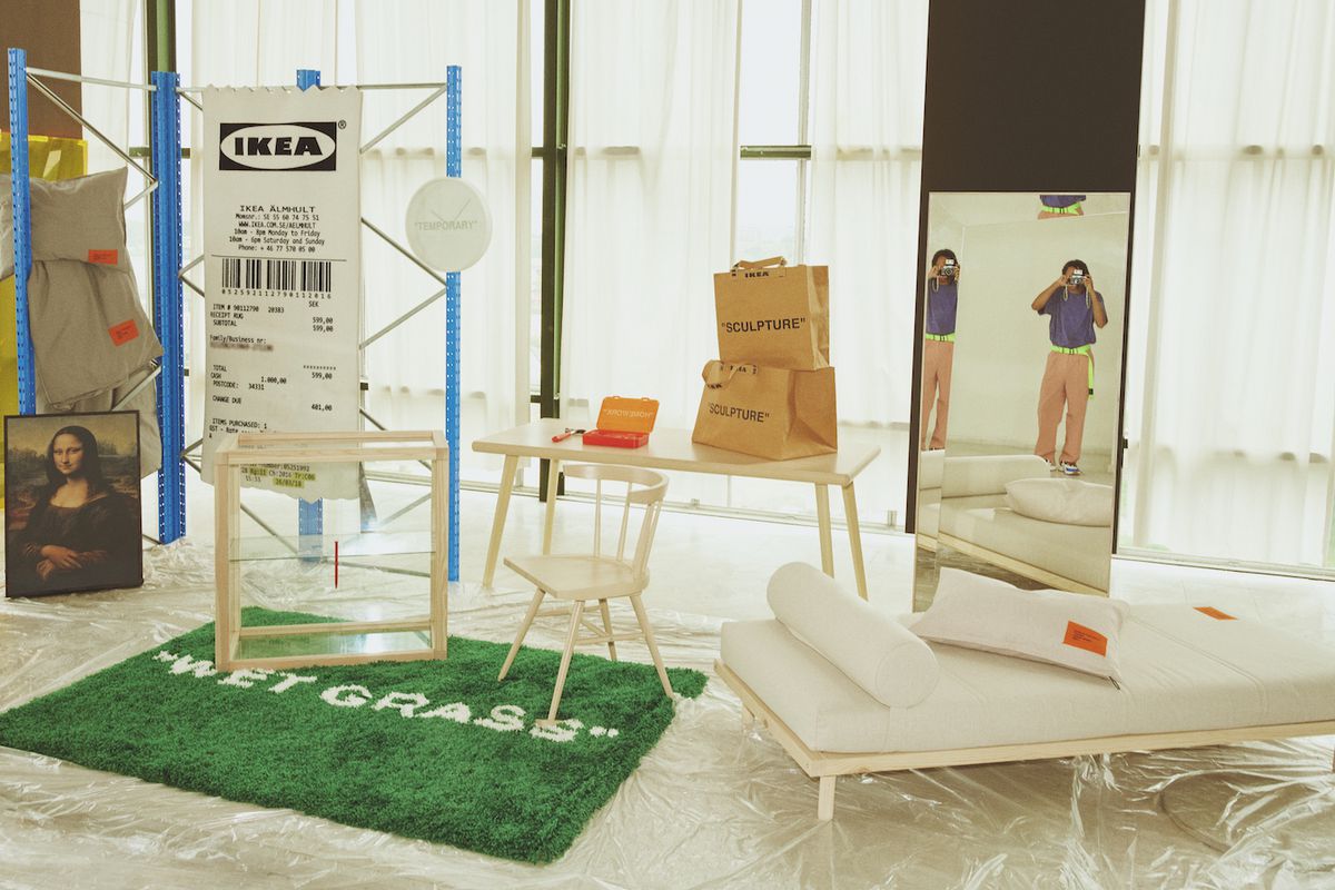 A group of furniture and decor items, including a green rug that says “Wetgrass” and a rug made to look like a shopping receipt. 
