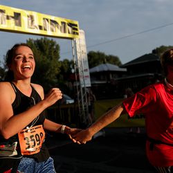 Laura Kelley and Nathan Kelley cross the finish line of the Deseret News 10K at Liberty Park in Salt Lake City on Tuesday, July 24, 2018.