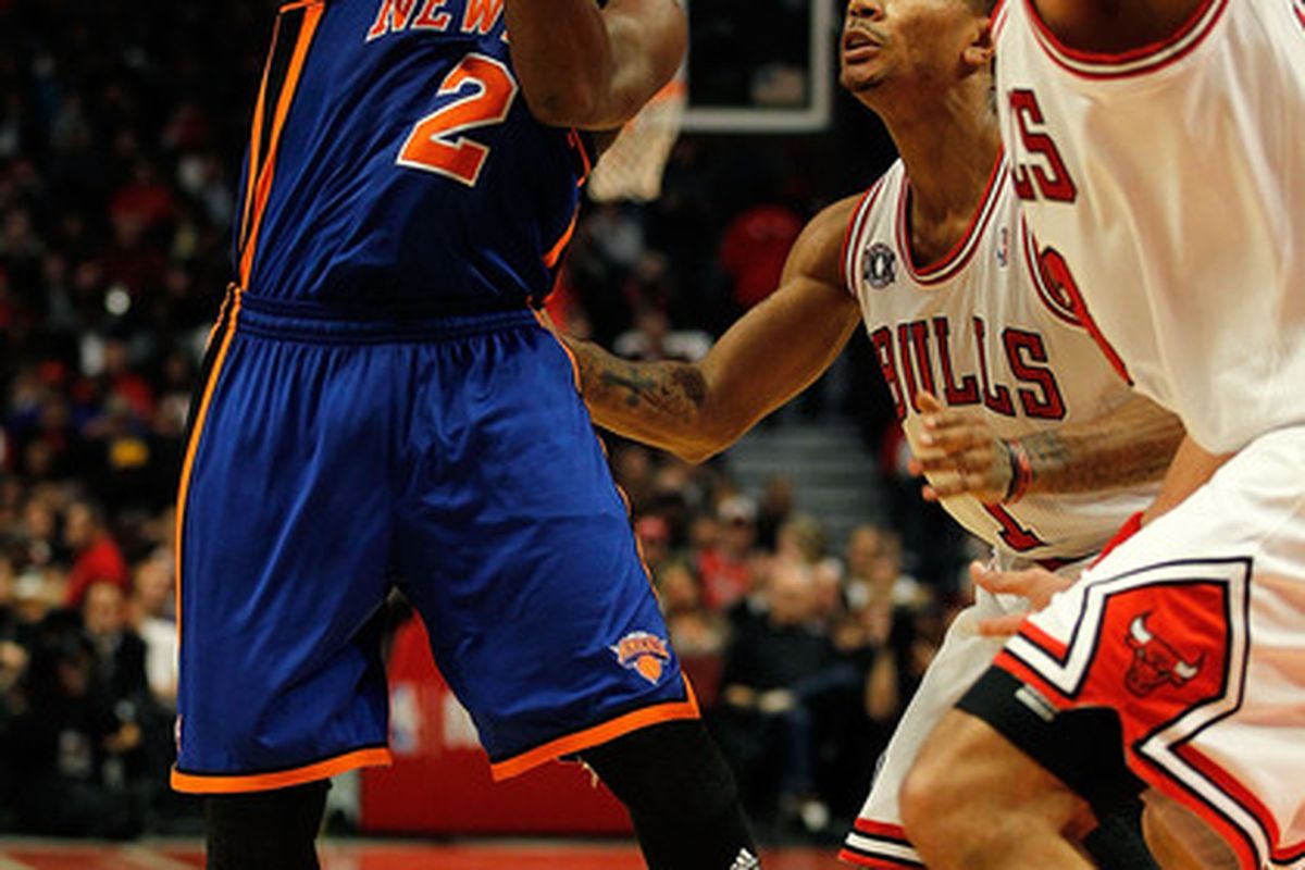 Raymond Felton of the New York Knicks passes the ball over Derrick Rose (1) and Joakim Noah (13) of the Chicago Bulls at the United Center on November 4 2010 in Chicago Illinois.  (Photo by Jonathan Daniel/Getty Images)