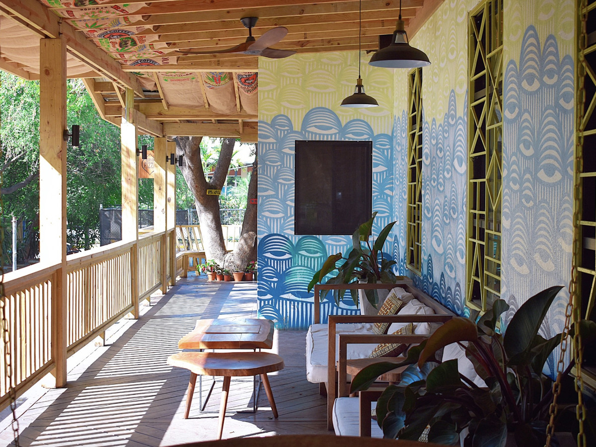 A loungey patio with many couches and a mural.