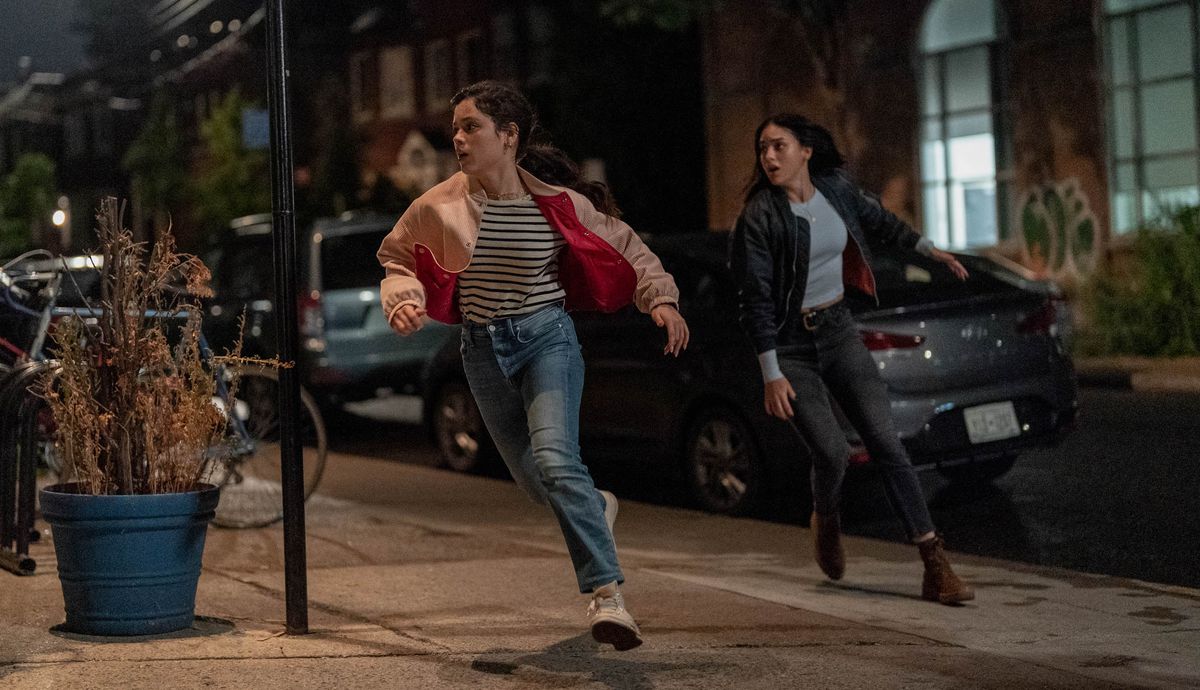 Siblings Tara and Sam Carpenter (Jenna Ortega and Melissa Barrera) flee in panic at night in front of some supposed New York buildings that really look like a cheap soundstage in Scream VI