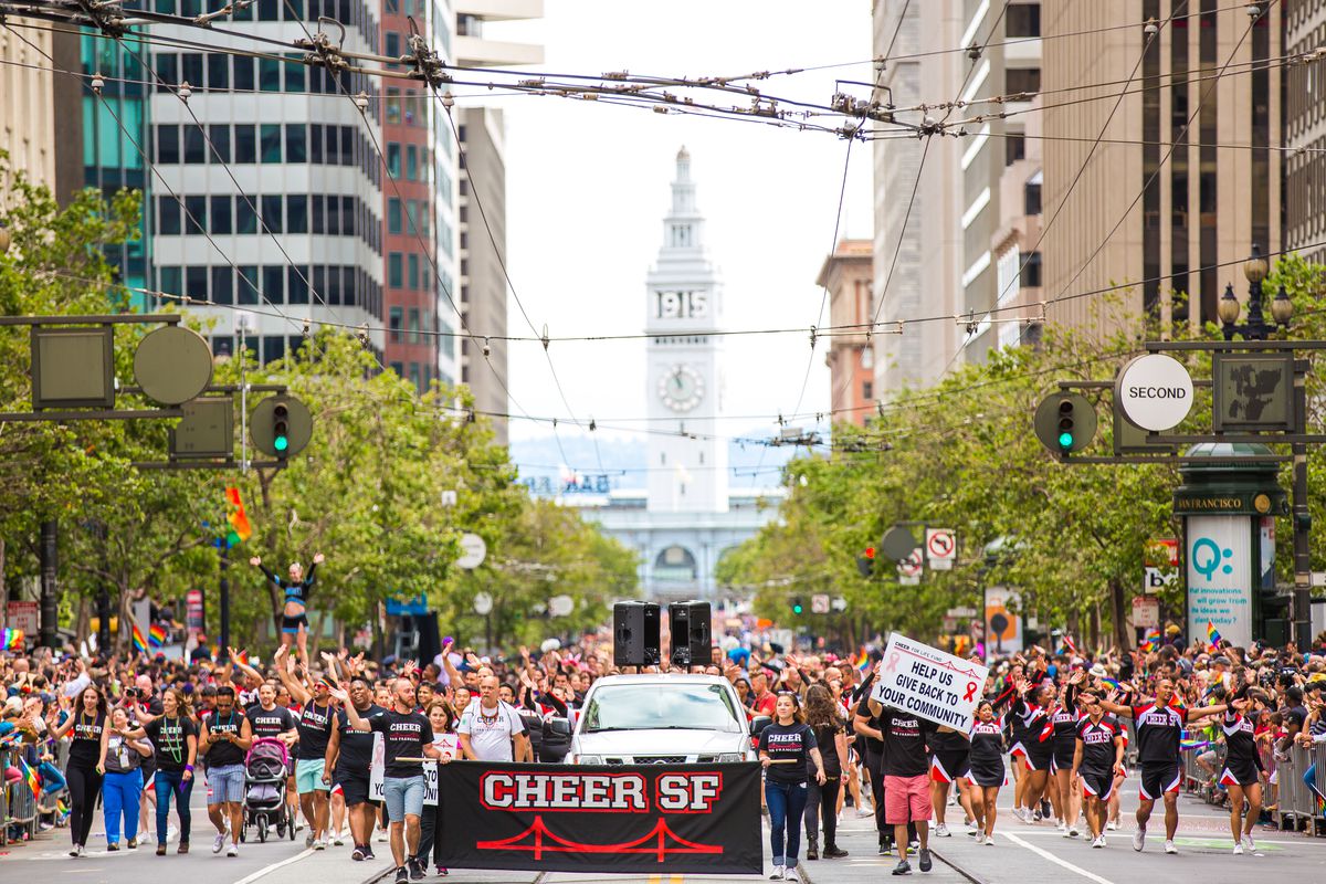 Image of Cheer SF cheerleaders at the 2015 SF Pride Parade marching down Market.  
