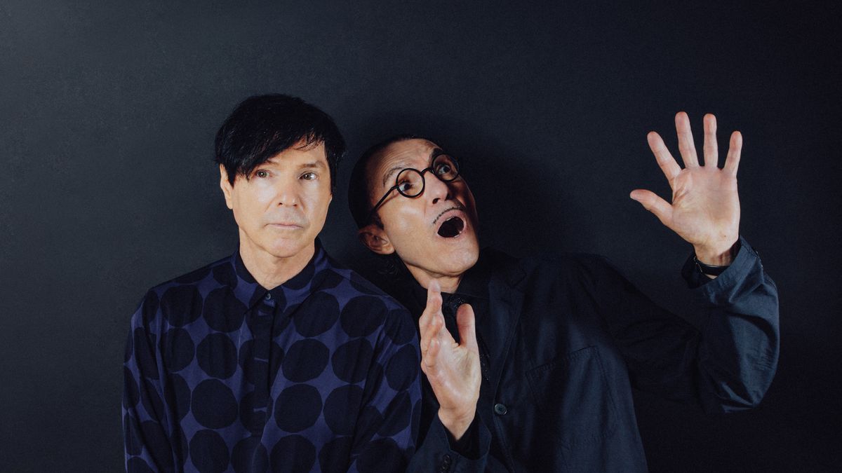 Russell and Ron Mael, in dark blue against a near identical dark blue background, mug for the camera in The Sparks Brothers