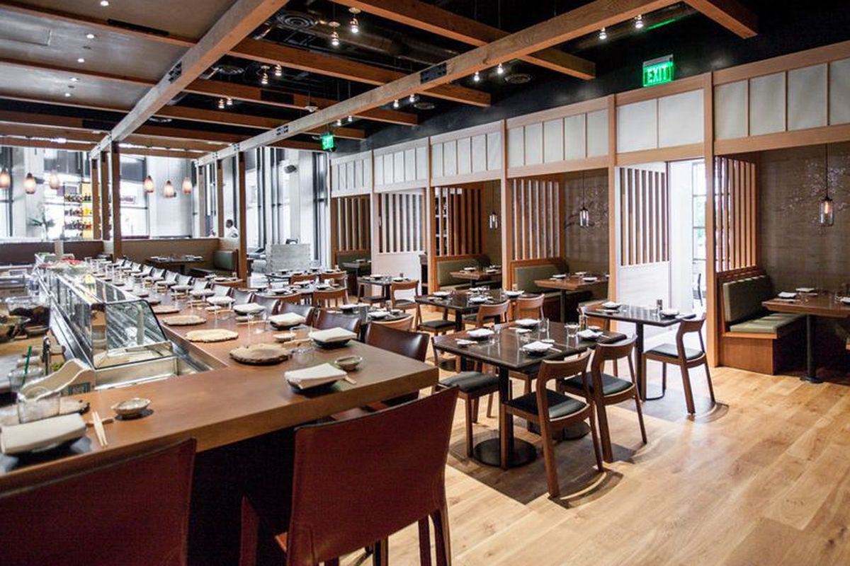 The Pabu dining room with a wooden sushi bar and enclosed banquettes along the back wall.